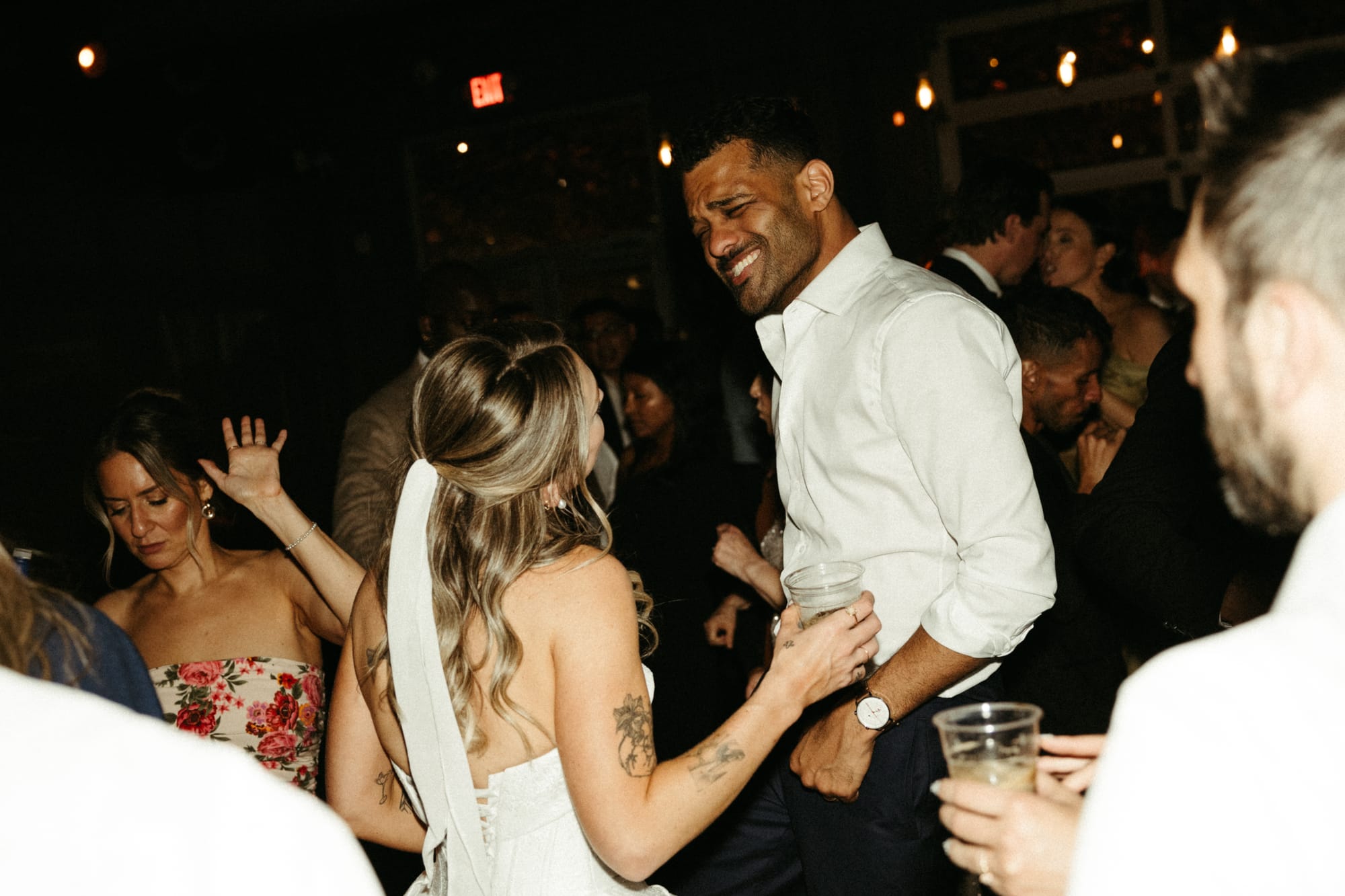 Bride and groom dancing at their wedding reception with guests around them