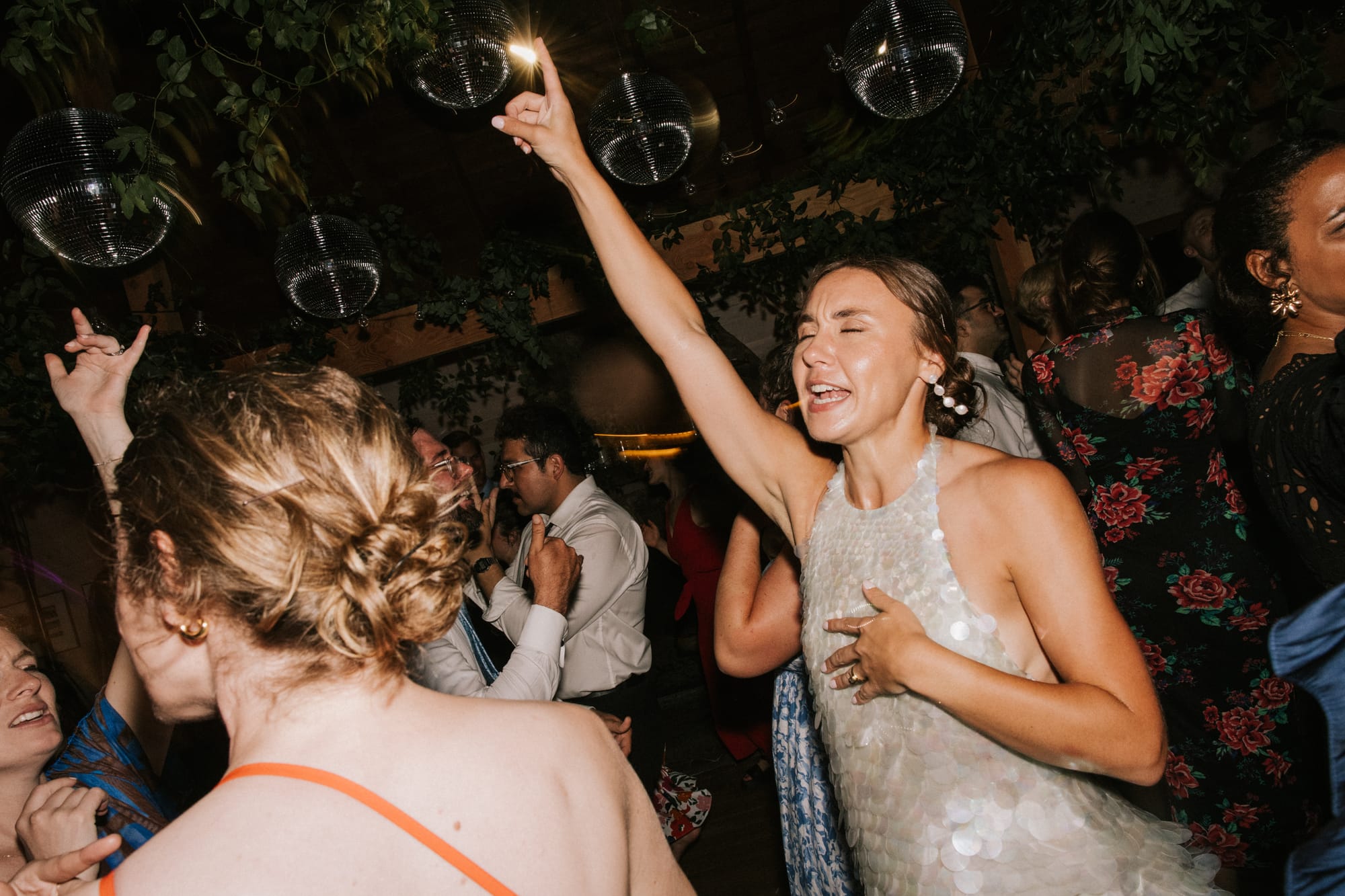 Bride dancing on a packed floor with the DJ running the night