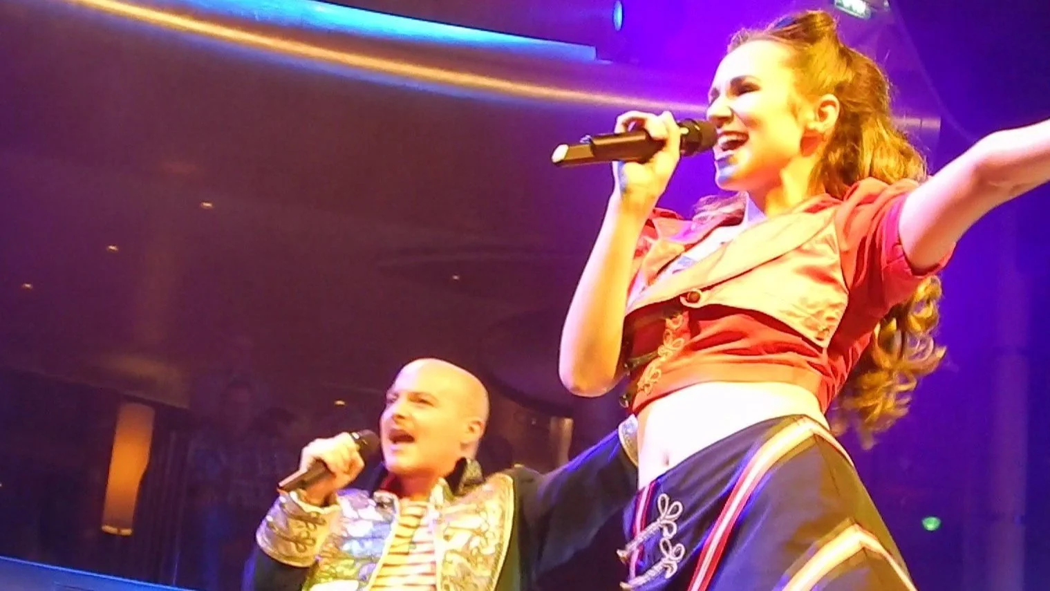 Emily and Tino of The Z Keys singing together on stage under show lights