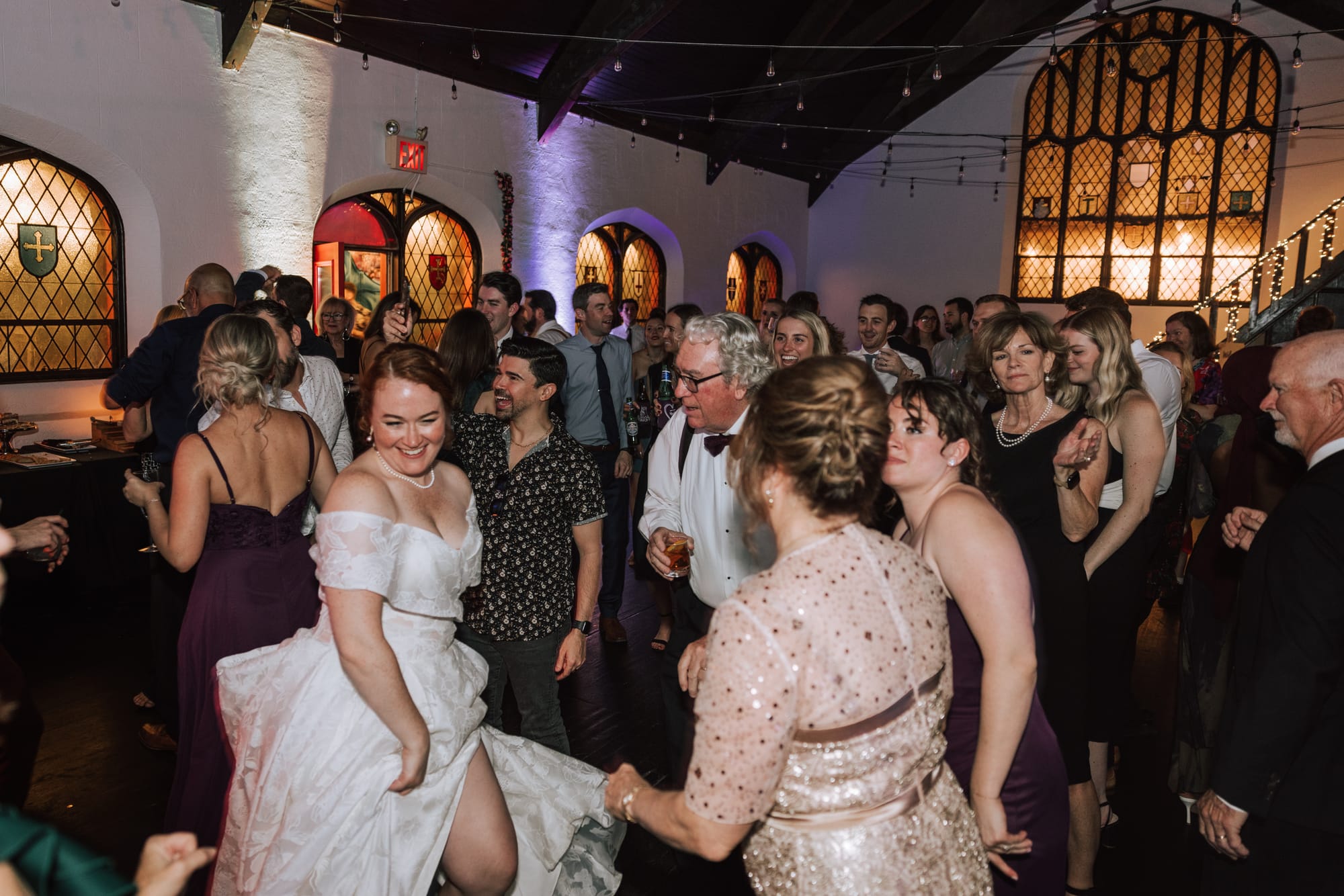 Guests and the bride dancing at a wedding reception with the live band