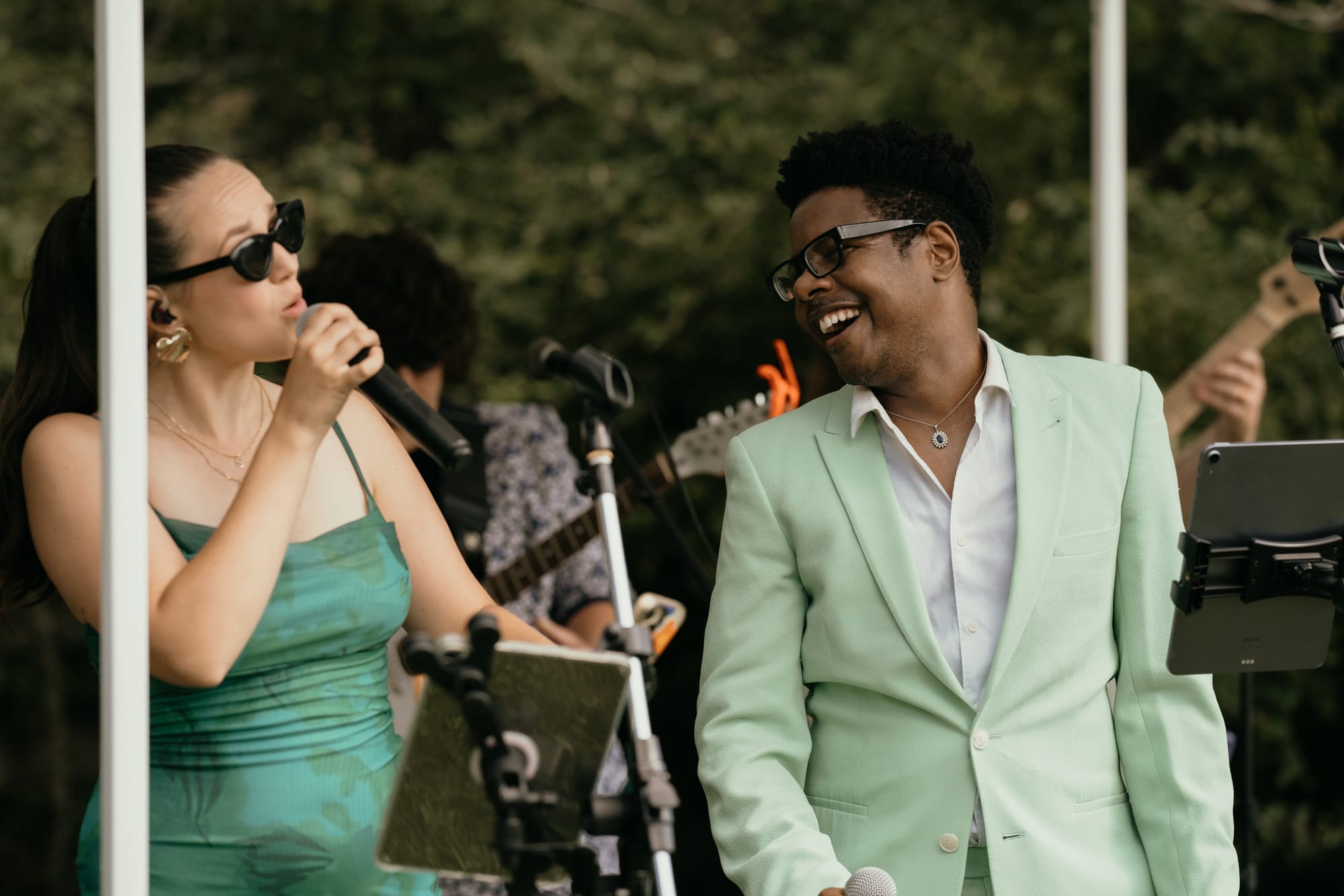 Two Z Keys lead vocalists singing together at an outdoor wedding reception
